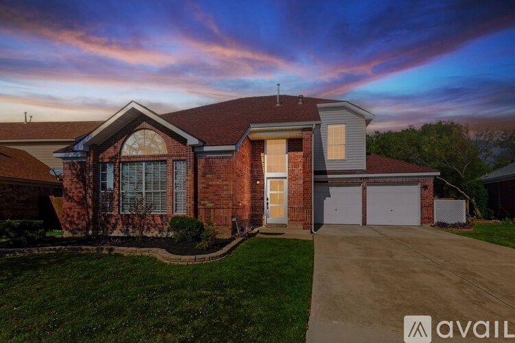A house with a brown brick facade and a white garage door is available for sale.