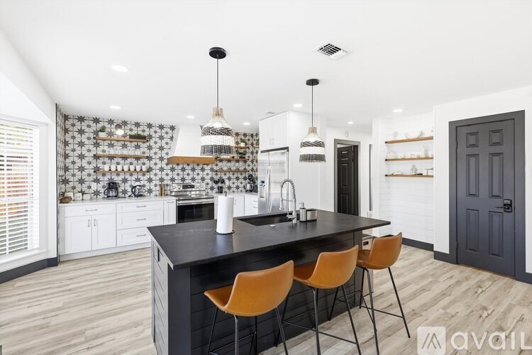 A kitchen with a black countertop and white cabinets.