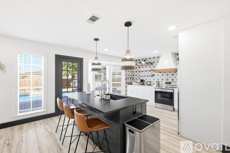 A kitchen with a black countertop and stainless steel appliances.