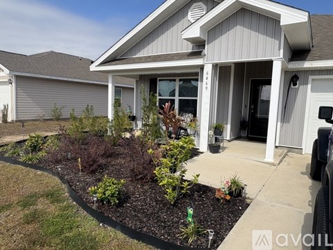 A house with a grey roof and a white front door.