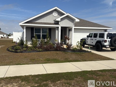 A house with a white car parked in front.