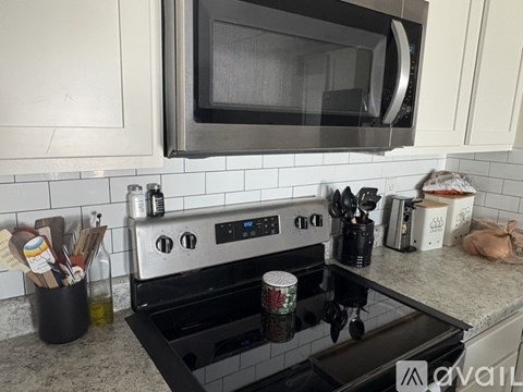 A modern kitchen with a black stove top and a microwave above it.