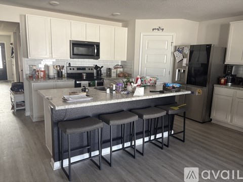 A kitchen with a bar stool in front of the island.