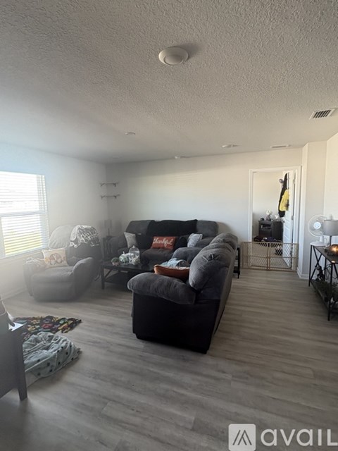 A living room with a grey couch and a grey chair.