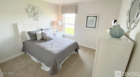 A bedroom with a bed, nightstand, and a framed picture on the wall.
