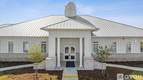 A white building with a black roof and a sign that says "available".