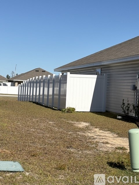 A white fence in front of a house.