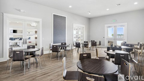A modern dining room with a round wooden table surrounded by chairs.