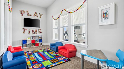 A play area with a colorful rug and a TV on the wall.