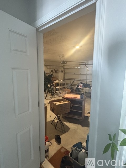 A room with a white door and a bicycle in the background.