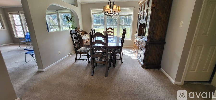 A dining room with a table and chairs.
