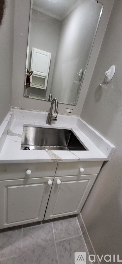 A bathroom with a sink and a mirror.