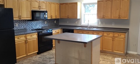 A kitchen with wooden cabinets and black appliances.