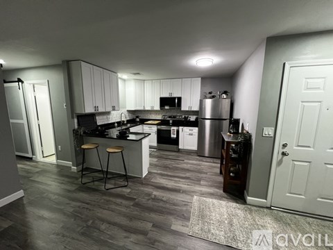 A kitchen with a black countertop and white cabinets.