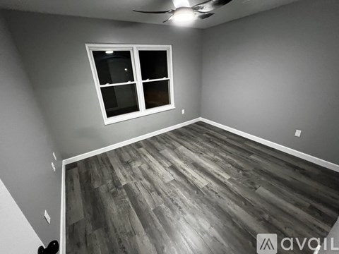 A room with wooden flooring and a window.