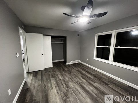 A room with a ceiling fan and a sliding door.