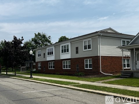 A grey and red brick house with a grey roof and a grey garage door.