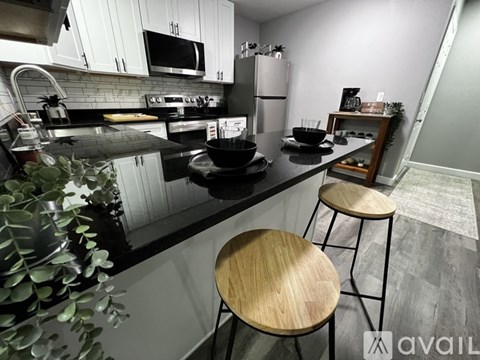 A kitchen with a black countertop and white cabinets.