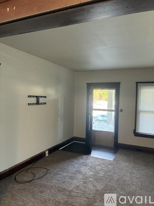 A room with a carpeted floor and a door leading to a balcony.