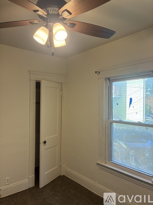 A room with a ceiling fan and a window.