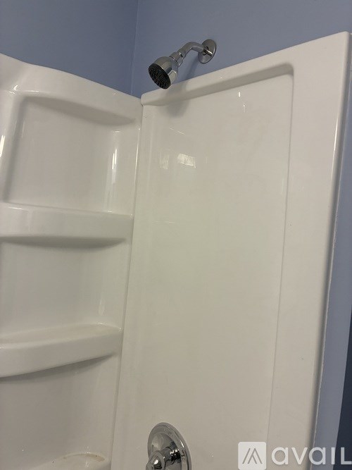 A white shower stall with a silver shower head.