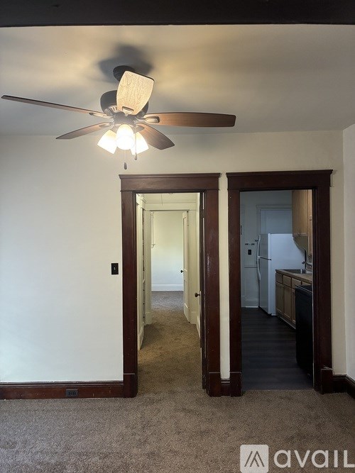 A room with a ceiling fan and a carpeted floor.