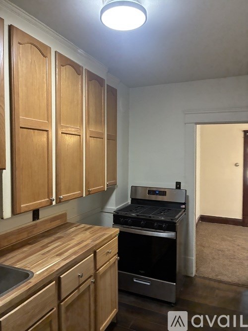 A kitchen with wooden cabinets and a stainless steel oven.
