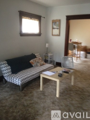 A living room with a sofa, a coffee table, and a lamp.