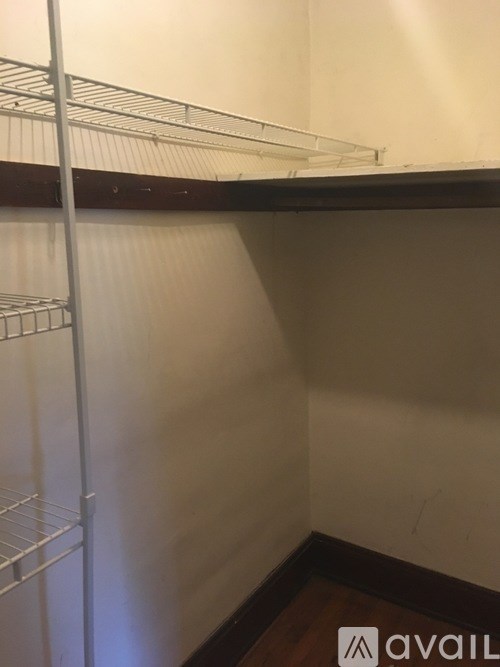 A white shelf in a corner of a room.