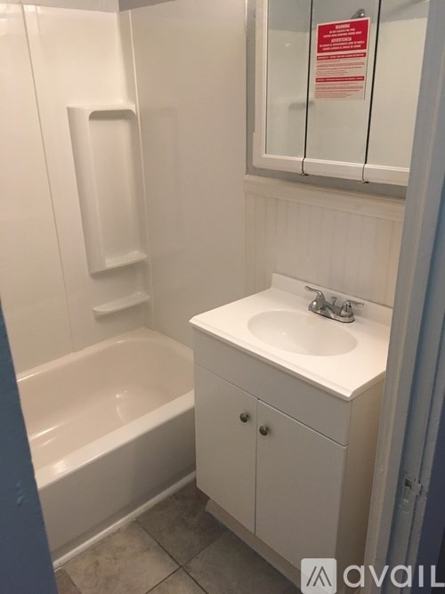 A white bathroom with a sink and a bathtub.
