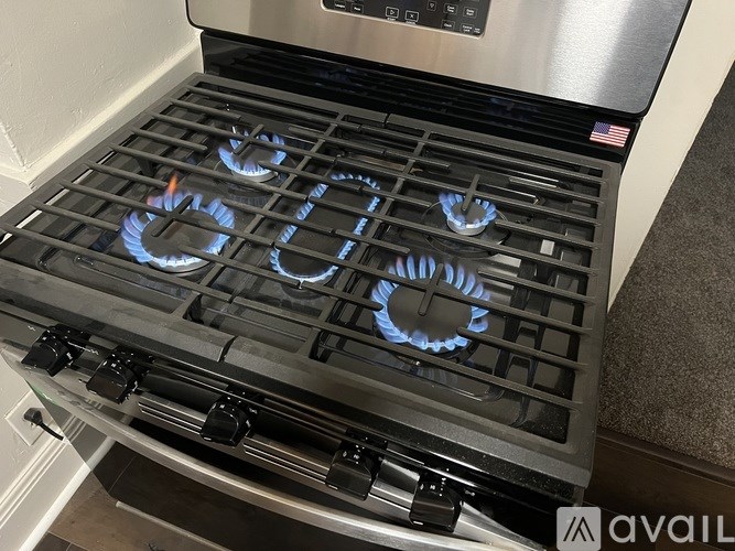 A stove top with four burners lit up.