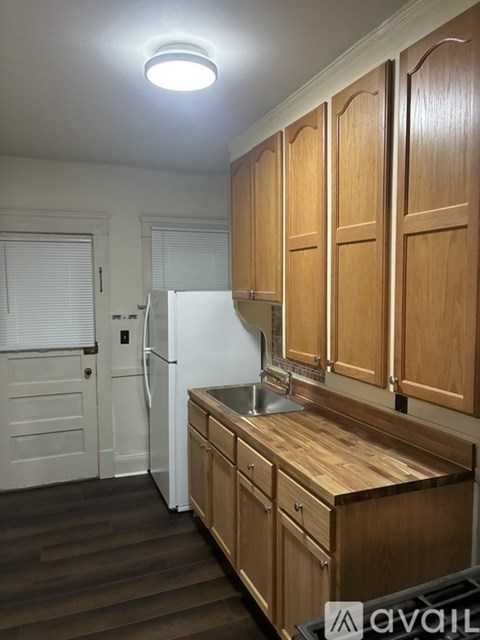 A kitchen with wooden cabinets and a white fridge.