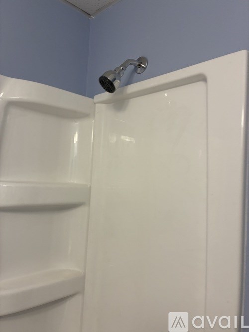 A white shower stall with a shower head.