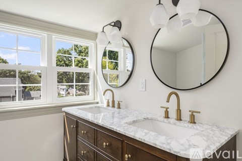 A bathroom with a marble countertop and a large window.