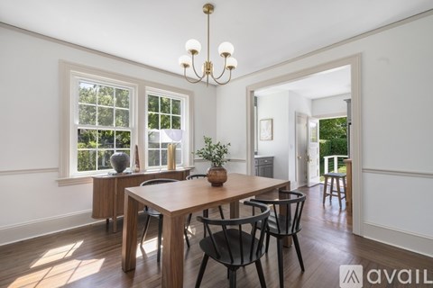A dining room with a wooden table and chairs.