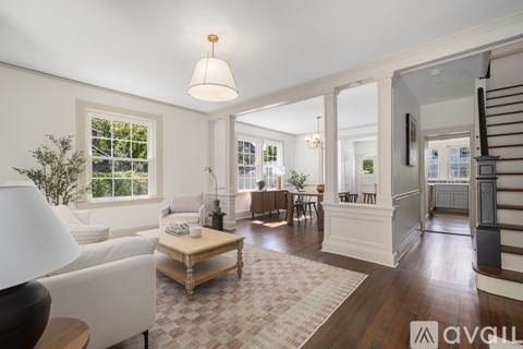 A well-lit living room with a white sofa and a wooden coffee table.
