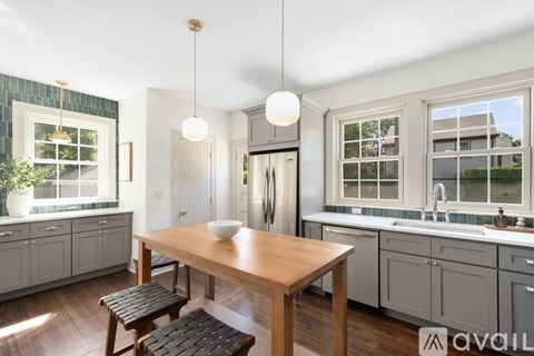 A kitchen with a table and chairs in the middle of it.