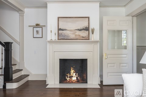 A fireplace with a painting above it and a white door to the right.
