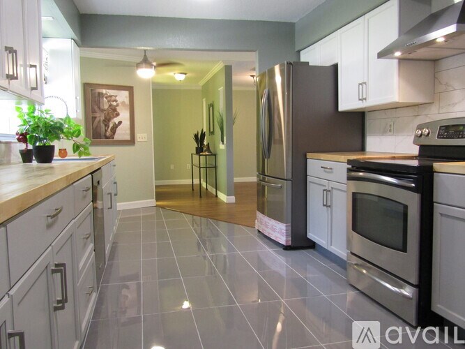 A kitchen with a refrigerator, oven, and sink.