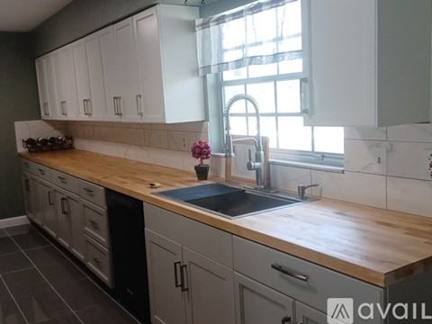 A kitchen with white cabinets and a wooden countertop.