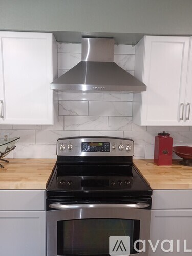 A kitchen with a stove top oven and a range hood.
