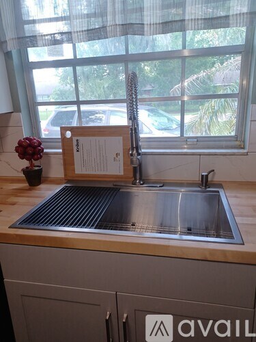 A kitchen sink with a wooden plaque above it.