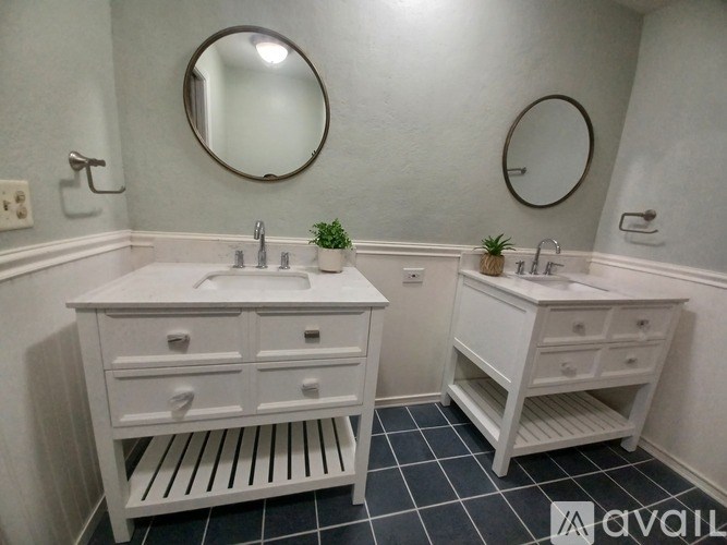 A bathroom with two sinks and two mirrors.