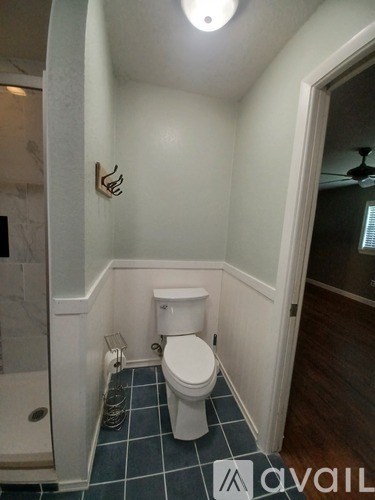 A small white toilet in a bathroom with a tiled floor.