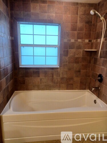 A bathroom with a tub and a window.