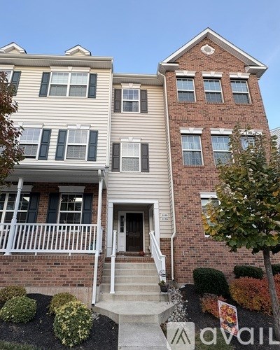 A two-story house with a white front porch and a brick facade.