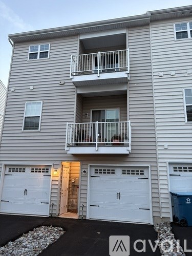 A two-story apartment building with a balcony on the second floor.