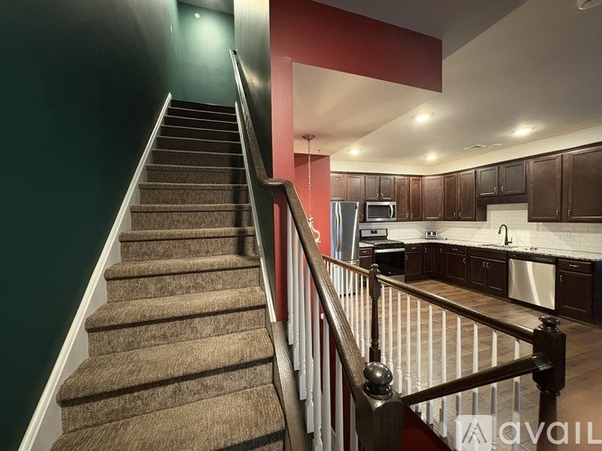 A staircase with a carpeted runner and a metal railing.