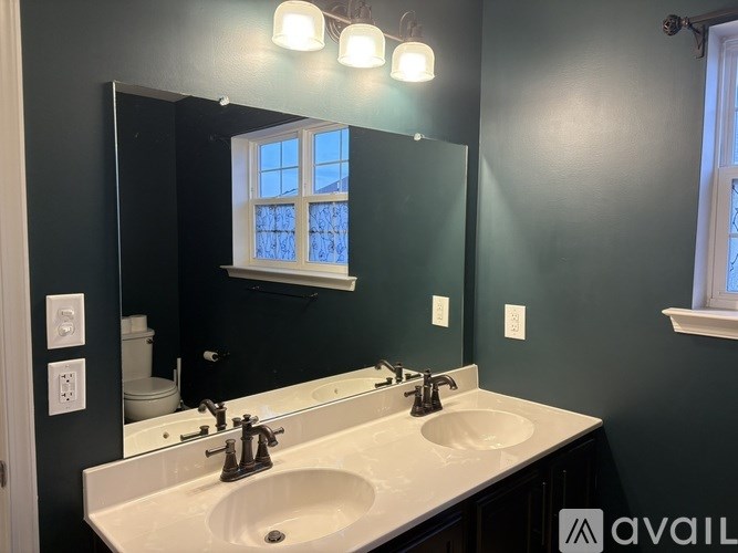 A bathroom with two sinks and a mirror.