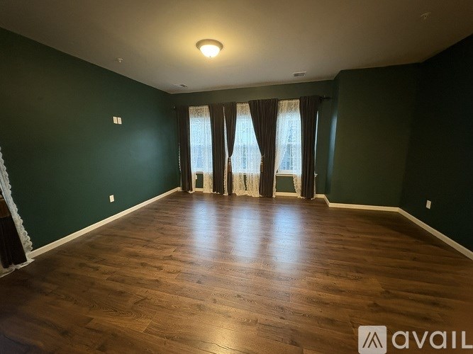 A room with dark green walls and wooden flooring.